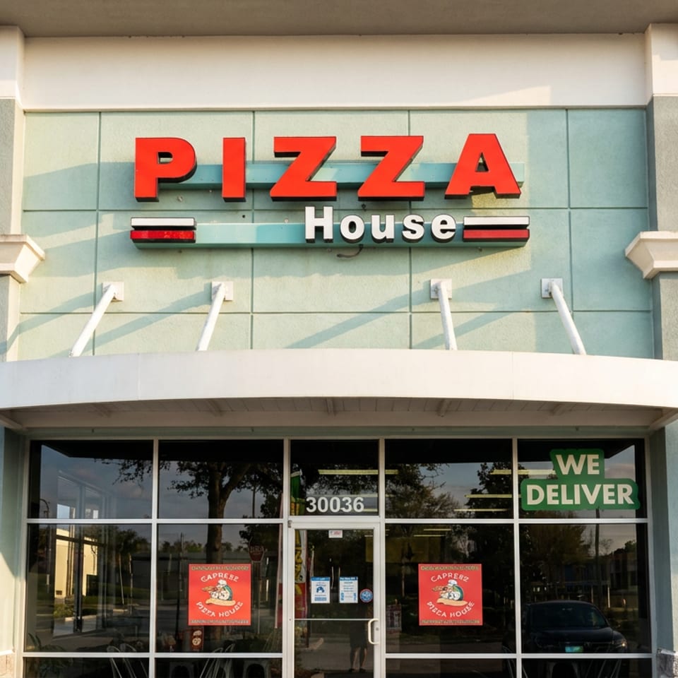 Exterior facade of a Pizza House restaurant with red signage, glass entrance, delivery notice, and address 30036.